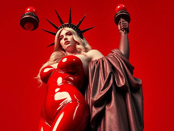 Tall, blonde curvy nude giant hugging the statue of liberty